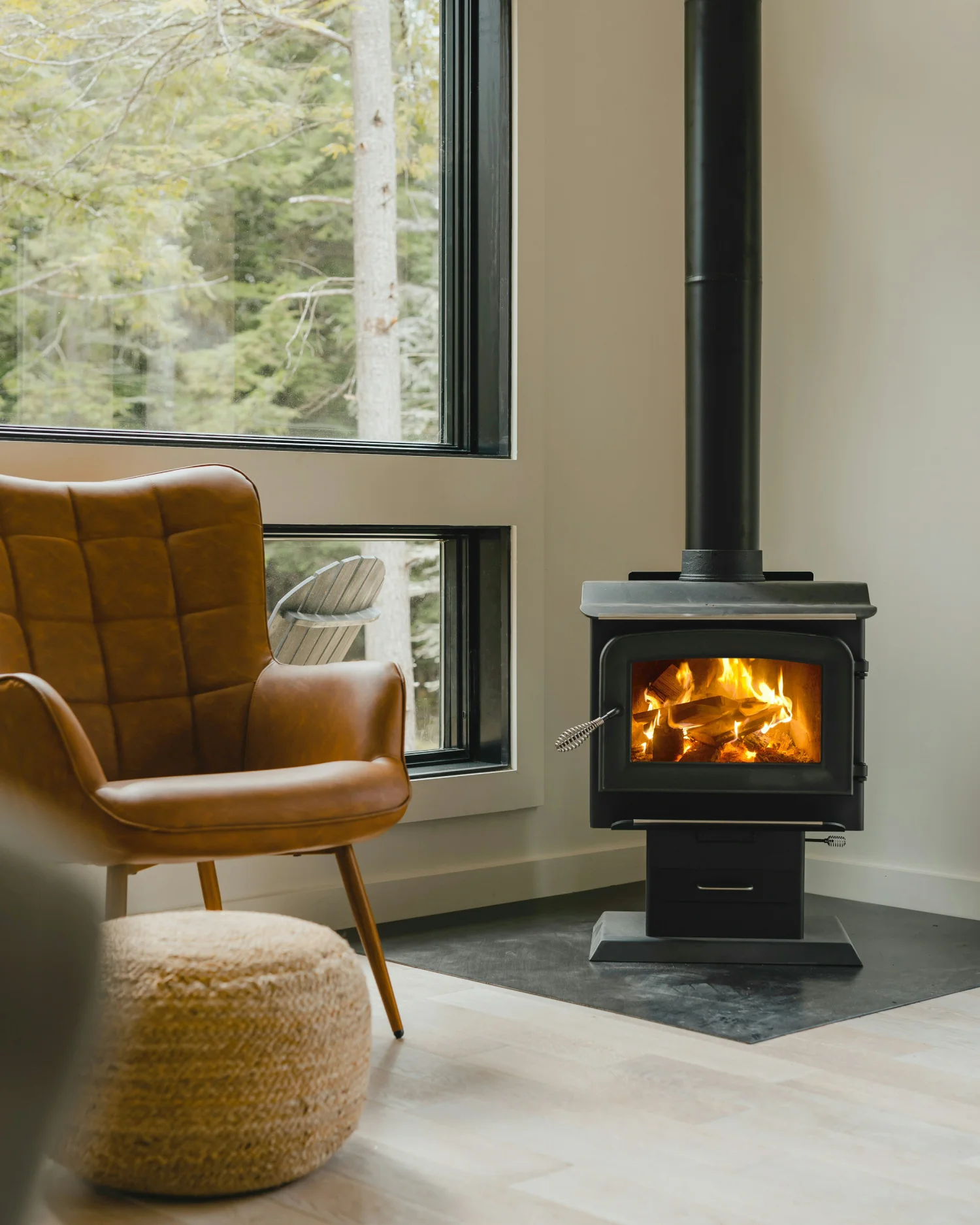 Moderner zylindrischer Kaminofen mit brennendem Holzfeuer